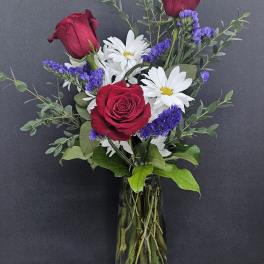 Red roses and white daisies in a glass vase