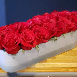 Long white box filled with red roses