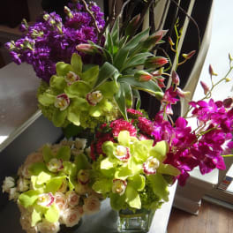 Bright orchid and rose arrangements in glass vases