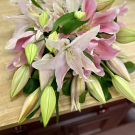 Pink and white lilies arranged in a bouquet on a table