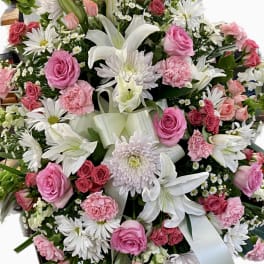 Pink and white mixed flower arrangement with lilies, roses, and daisies