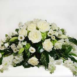 White roses and lilies arranged in a low floral spray