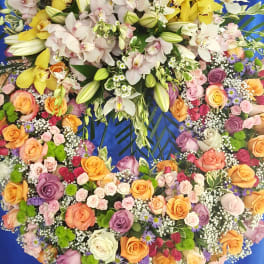 Large floral wreath with orchids and roses on a blue backdrop