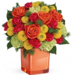 Bouquet of orange roses, red carnations, and yellow pompons in an orange vase
