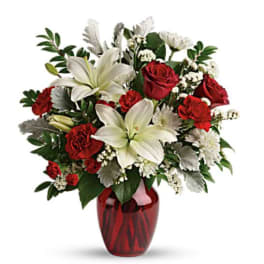Red roses and white lilies in a red glass vase