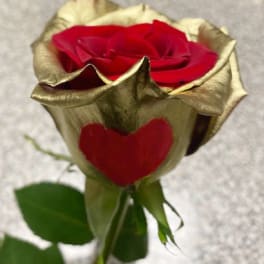 Single red rose with gold-tinted petals and a heart-shaped petal accent