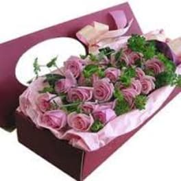 Pink roses arranged in a gift box with tissue paper