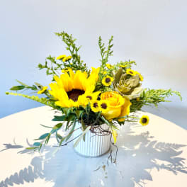 Sunflower and yellow rose arrangement in a white ribbed vase