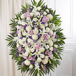 Large white and purple floral standing spray on an easel