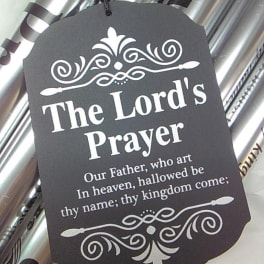 Black prayer tag hanging on silver wrapped gift packaging