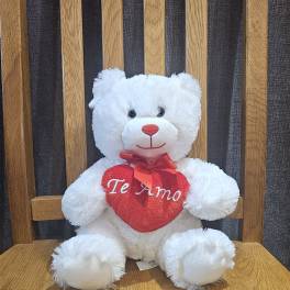 White teddy bear holding a red heart with "Te Amo" text