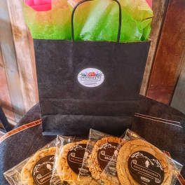 Gift bag with wrapped cookies on a chair