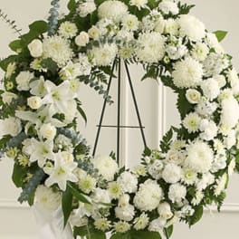 Large white floral wreath on a black stand