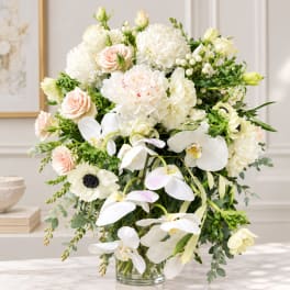 Large white and blush floral arrangement in a clear glass vase