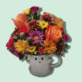 Colorful flower arrangement in a white ghost-shaped mug
