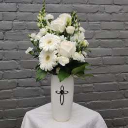 White roses and gerbera daisies in a tall white vase