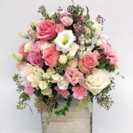 Pink and white rose and carnation arrangement in a rustic wooden box