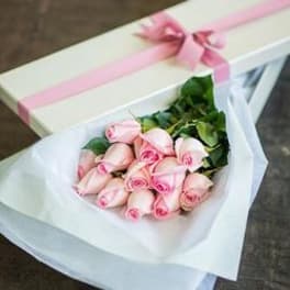 Bouquet of pale pink roses wrapped in white paper