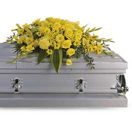 Yellow floral spray on a white casket