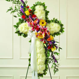Large floral standing cross with white blooms and colorful flowers