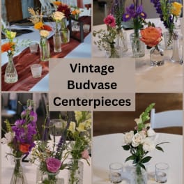 Vintage bud vase centerpieces with mixed flowers in glass bottles