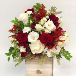 Red and white rose arrangement in a wooden box