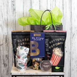Gift basket with mugs, popcorn, hot chocolate, and chocolates