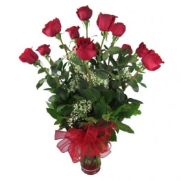 Red roses in a glass vase with a red ribbon bow