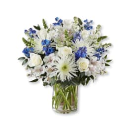 White and blue mixed bouquet in a clear glass vase