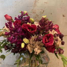 Bouquet of red and purple flowers in a clear glass vase