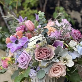 Pastel bouquet of roses, anemones, and tulips in a white vase
