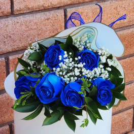 Bouquet of blue roses with white baby's breath in white wrapping