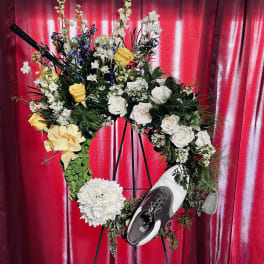 Floral wreath on an easel with white and yellow flowers and a shoe
