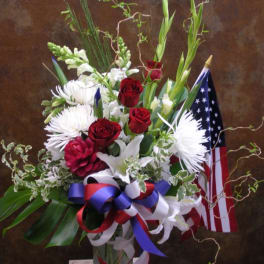 Red roses and white flowers in a vase with an American flag