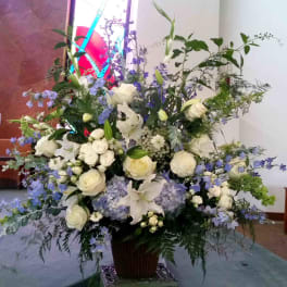 Large white and lavender floral arrangement in a tall vase