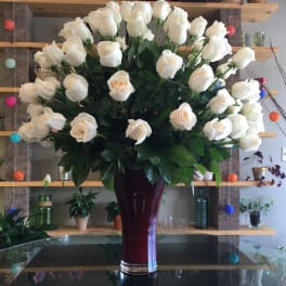 Large bouquet of white roses in a tall burgundy vase