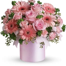 Pink roses and gerbera daisies in a pink hatbox with ribbon
