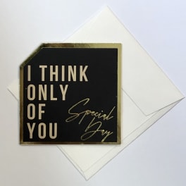 Black greeting card with gold text reading "I THINK ONLY OF YOU"