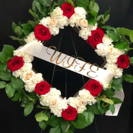 Heart-shaped floral wreath with red and white roses and a "WIFE" ribbon