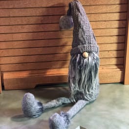 Knitted gnome figurine with long gray beard and dangling legs