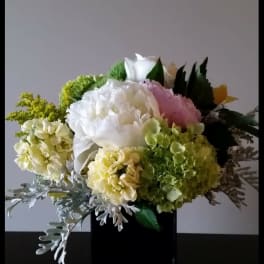 Bouquet of white, pink, and green flowers in a black vase