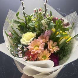 Mixed bouquet with pink and peach daisies, tulips, and pussy willow stems