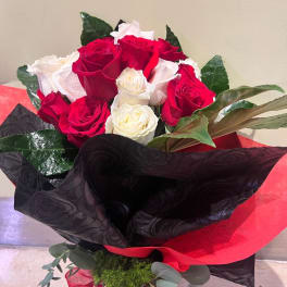 Bouquet of red and white roses wrapped in black and red paper