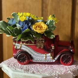 Flowers arranged in a red vintage car planter