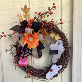 Halloween wreath with orange flower, ghosts, and berry accents