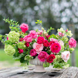 Pink and red rose arrangement in a white vase