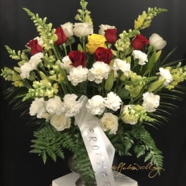 Large floral spray with red, white, and yellow roses and white carnations