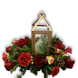 Red roses and carnations arranged around a gold lantern