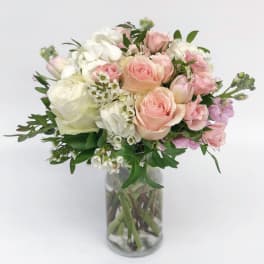 Pink and white rose bouquet in a clear glass vase