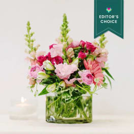 Pink mixed flower arrangement in a square glass vase